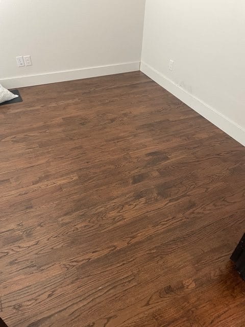 dark hardwood flooring with white baseboards