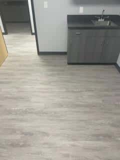 gray hardwood flooring with sink in right corner