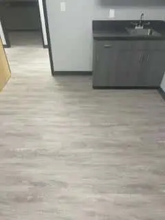Grey sink installed on gray wood flooring